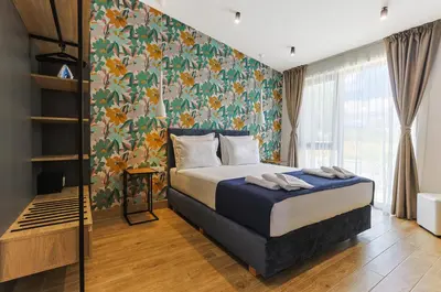 a bedroom with a bed with a floral wall at Terme di Hissar Village in Hisarya