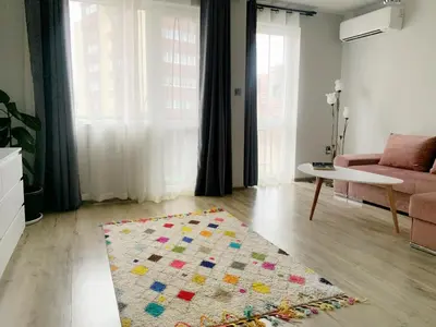 a living room with a couch and a rug on the floor at Altavista mountain apartment in Samokov