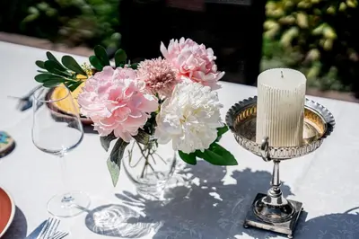 a vase filled with pink and white flowers on a table at Къща за гости ЗЕЛЕНА in Vinogradets