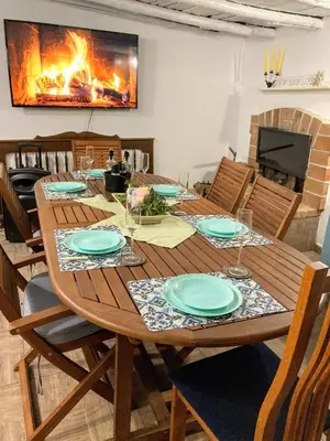 a wooden dining room table with chairs and a fireplace at Къща за гости ЗЕЛЕНА in Vinogradets