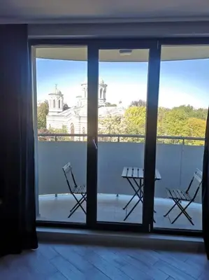 a balcony with a view of a building through glass doors at Apartment Opalchenska / Pirotska in Sofia