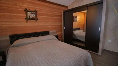 a bedroom with a bed and a large mirror at Boutique Villas Murgavets Pamporovo in Pamporovo