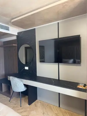 a desk with a mirror and a tv on a wall at OASIS RESORT RHODOPES in Dospat