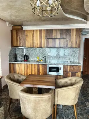 a kitchen with a wooden table and two chairs at OASIS RESORT RHODOPES in Dospat