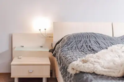 a bedroom with a bed and a nightstand with a lamp at Your home away from home in Sofia