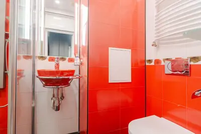 a red bathroom with a toilet and a sink at Your home away from home in Sofia