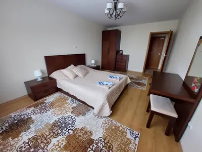 a bedroom with a bed and a table and a desk at Apartment Pirin in Bansko