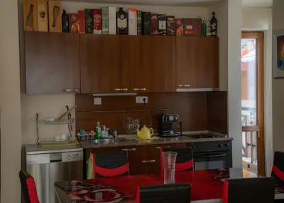 a kitchen with wooden cabinets and a table with chairs at Апартамент ДЕНИ in Pamporovo