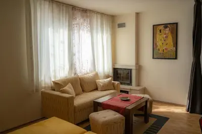 a living room with a couch and a table at Апартамент ДЕНИ in Pamporovo