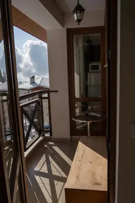 a balcony with a table and a view of a building at Апартамент ДЕНИ in Pamporovo