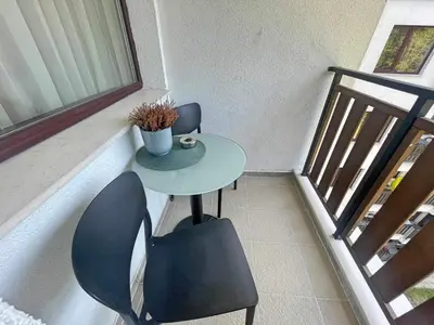 a table and chairs in a room with a window at Arboro Borovets Gardens E50 in Borovets