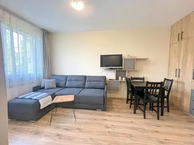 a living room with a blue couch and a table at Arboro Borovets Gardens E50 in Borovets