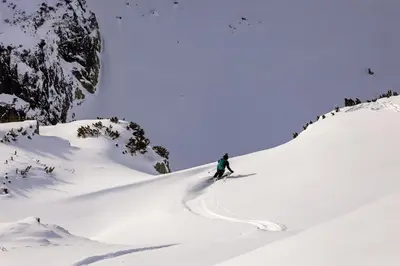 a person is skiing down a snow covered mountain at Arboro Borovets Gardens E50 in Borovets