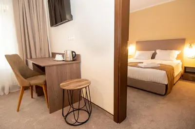 a hotel room with a bed and a table and chair at Hotel Alpinist, Malyovitsa in Govedartsi