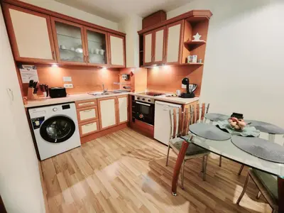 a small kitchen with a table and a laundry machine at Arboro Royal Plaza in Borovets