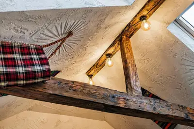 a ceiling with a plaid pillow on a wooden beam at Sofia Folklore Life Apartment in Sofia