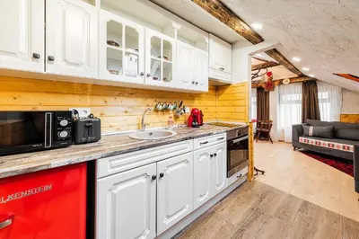 a kitchen with white cabinets and a red appliance at Sofia Folklore Life Apartment in Sofia