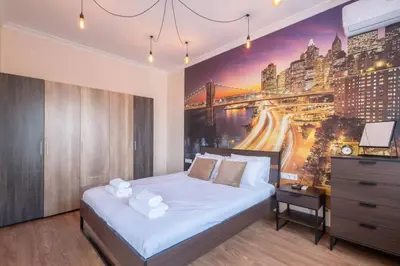 a bedroom with a bed and a painting of a city at Budget Stay in City Center near NDK in Sofia