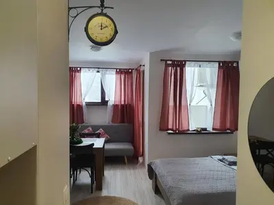 a room with a bed and a clock on the wall at Апартамент B9 in Borovets