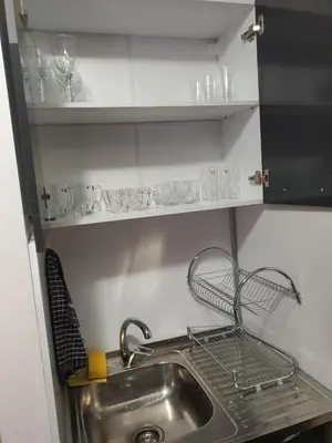 a kitchen with a sink and a shelf with glasses at Апартамент B9 in Borovets