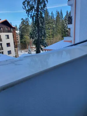 a snow covered roof of a building with trees at Апартамент B9 in Borovets