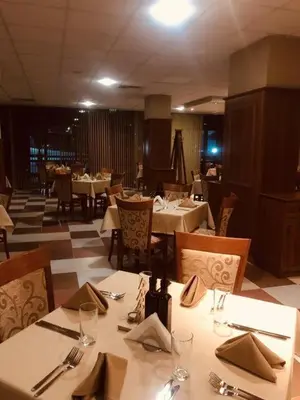 a dining room with white tables and chairs and tablesearcher at Апартамент B9 in Borovets