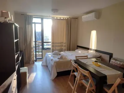 a bedroom with a bed and a table with chairs at Студио Пацо и Нина в AspenValley in Razlog