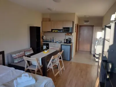 a kitchen and a living room with a table and chairs at Студио Пацо и Нина в AspenValley in Razlog