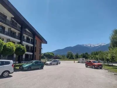 a parking lot with cars parked in front of a building at Студио Пацо и Нина в AspenValley in Razlog
