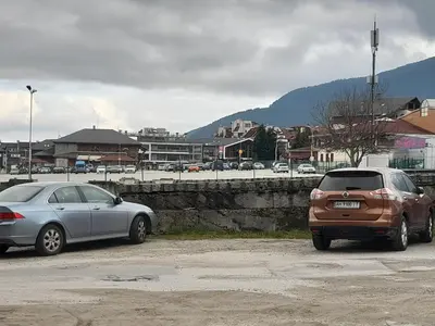 two cars parked next to each other in a parking lot at SNOW PEAK TODORKA APARTAMENT /NEXT TO THE LIFT/ 6 PERSONS in Bansko