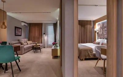 a hotel room with a bed and a living room at City Park Inn Apartment Cortona in Plovdiv