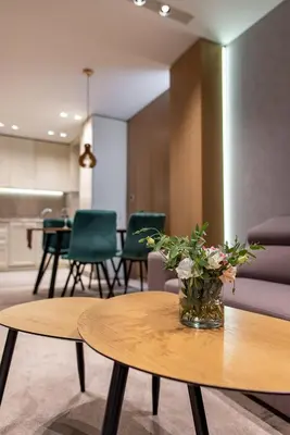 a room with two tables and a vase of flowers at City Park Inn Apartment Cortona in Plovdiv