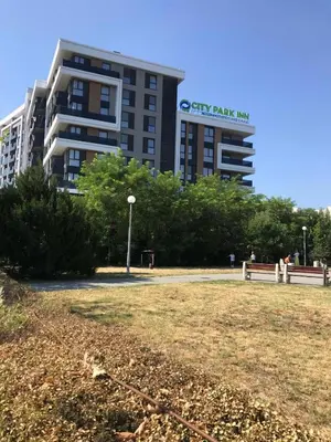 a large building with a park in front of it at City Park Inn Apartment Cortona in Plovdiv