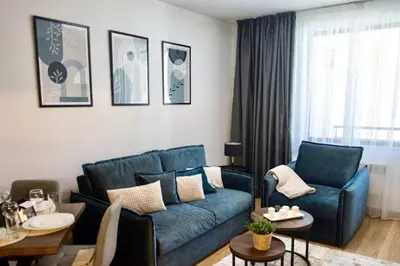 a living room with a blue couch and a table at Antonovi Apartments 2 in hotel Laplandia in Pamporovo