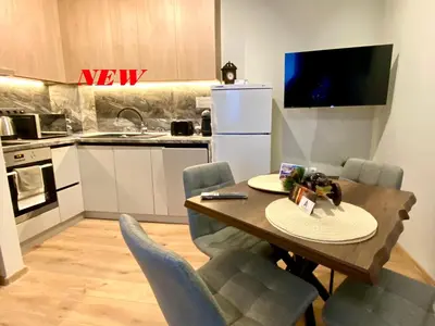 a kitchen with a table and chairs in a kitchen at Antonovi Apartments 2 in hotel Laplandia in Pamporovo
