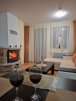 two glasses of wine sitting on a table in a living room at Ski Area @ Apartment Rosea 205 @ Pamporovo in Pamporovo