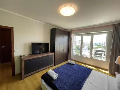 a bedroom with a bed and a tv and a window at Amazing view central 1 bedroom apartment in Pazardzhik