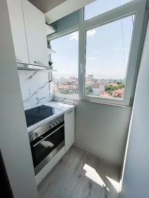 a kitchen with a stove and a large window at Amazing view central 1 bedroom apartment in Pazardzhik