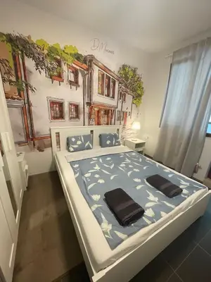 a bedroom with a large bed with a blue blanket at Top Center 2-BR Apartment with lovely Outdoor Area in Plovdiv