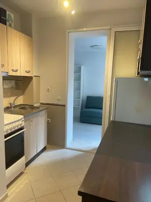 a kitchen with a blue couch in the background at Top Center 2-BR Apartment with lovely Outdoor Area in Plovdiv