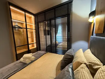 a bedroom with a bed and a large window at Ski Bansko Design Apartments in Bansko