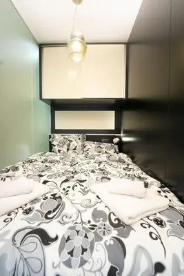 a bedroom with a black and white bed with a cat sitting on it at Secluded Mountain Cozy Studio with Fireplace in Bansko