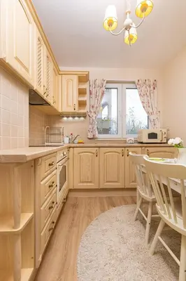 a kitchen with wooden cabinets and a table and chairs at Bright & Cozy 1BD Flat with a Terrace and Parking by Flat Mаnager in Plovdiv