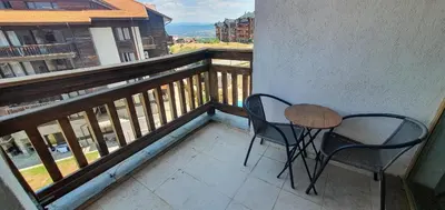 a balcony with two chairs and a table on a balcony at Penthouse Harriet Bansko in Bansko
