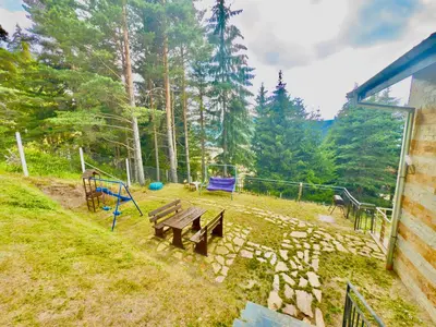 a backyard with a picnic table and a playground at Къщи за гости Фантазия in Dospat
