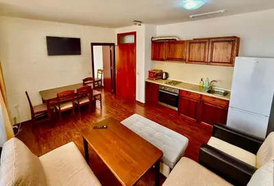 a kitchen and living room with a couch and a table at Къщи за гости Фантазия in Dospat