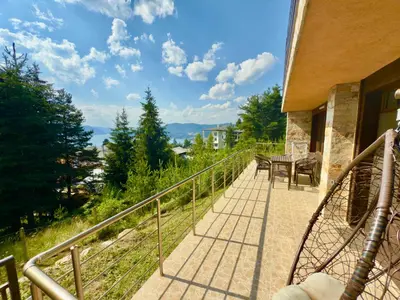 a balcony of a house with a table and chairs at Къщи за гости Фантазия in Dospat