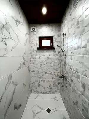 a bathroom with a shower and a stone wall at Roots Apartment 2 in Borovets