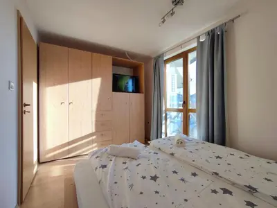 a bedroom with a bed and a window at Pirin Sunrise in Bansko