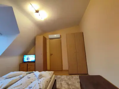 an attic bedroom with a bed and a television at Pirin Sunrise in Bansko